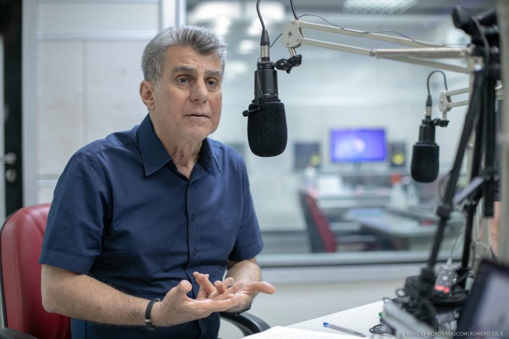 Romero Jucá falando no microfone em estúdio de rádio. Falou sobre a vida