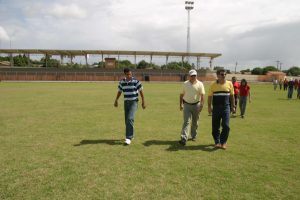 Romero Jucá e outras pessoas andando em campo da Vila Olímpica
