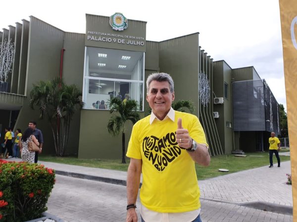 Romero Jucá faz sinal de positivo em frente da nova sede da Prefeitura de Boa Vista. Ele usa camisa amarela