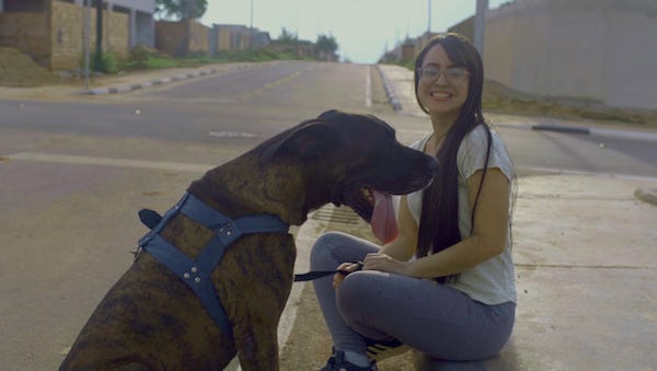 Moradora com cachorro em rua asfaltada no Cidade Universitária em Boa Vista