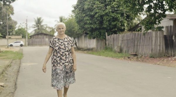 Dona Eva caminha pela rua asfaltada em que mora. Asfalto em Mucajaí era o sonho dela