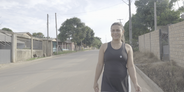Kassia Rodrigues com roupa de caminhar sorri com o asfalto em Caroebe